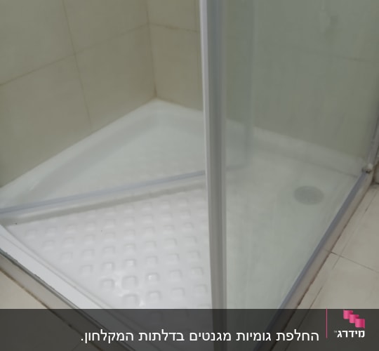מקלחון פינתי עם דלת זכוכית ומגש פלסטיק